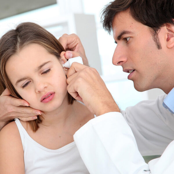 Девојка ја прегледува лекар за инфекција на увото.