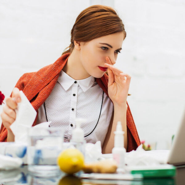Болна жена со настинка во канцеларија.