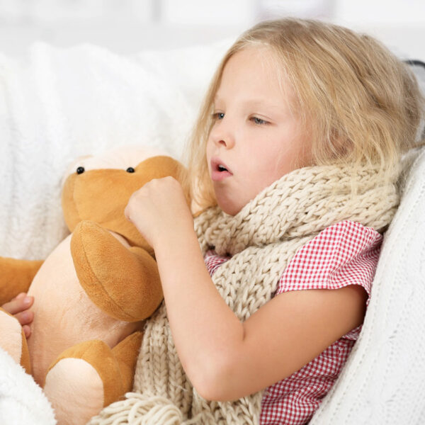 Болно девојче се држи за плишана играчка.