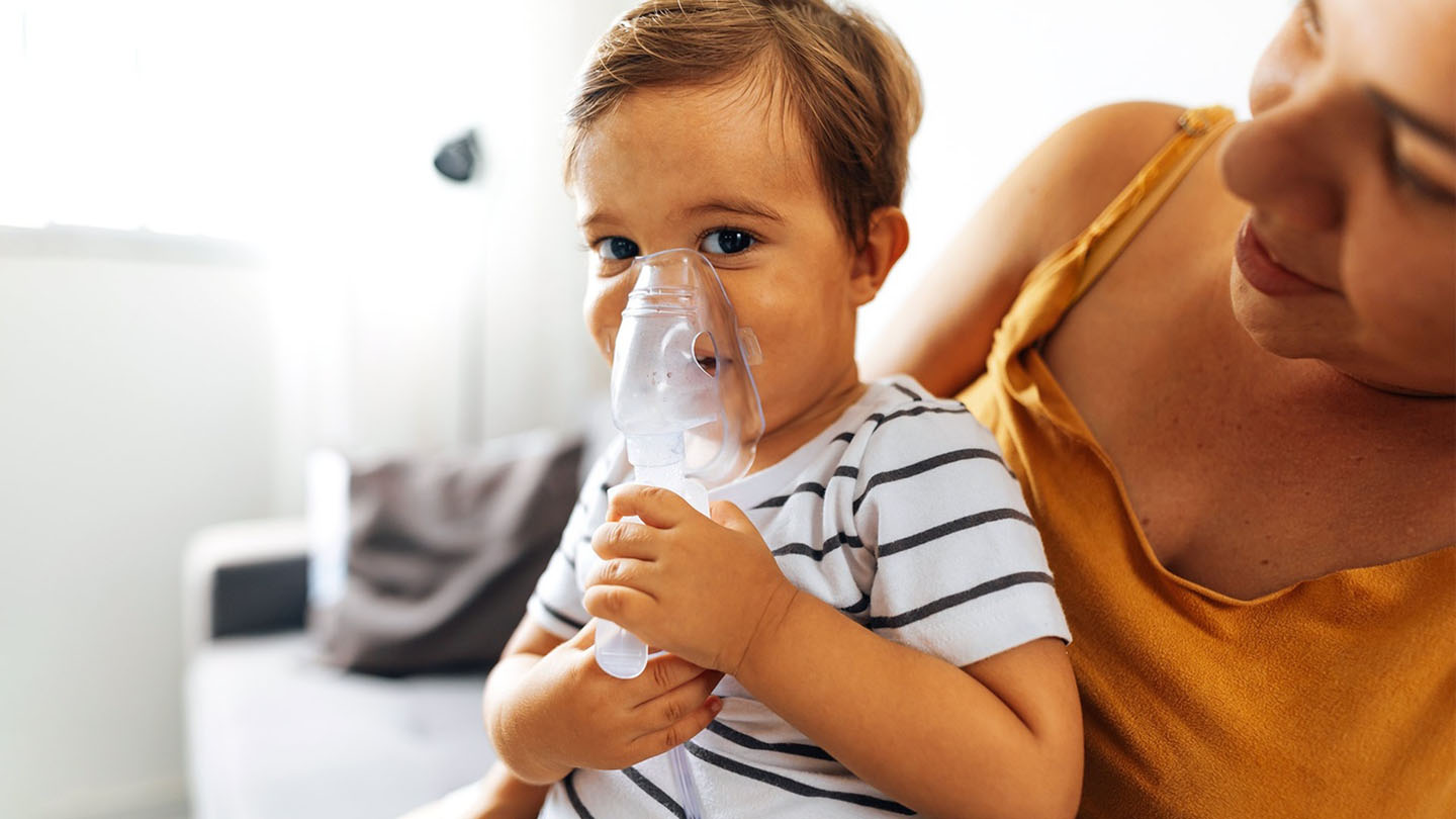 Дете со маска за дишење и неговата мајка.