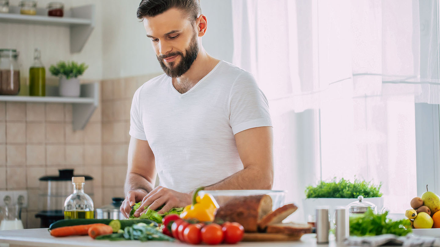 Машки спортист подготвува здрав оброк во кујната.